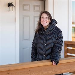 Kirsten stands in front of her new home.