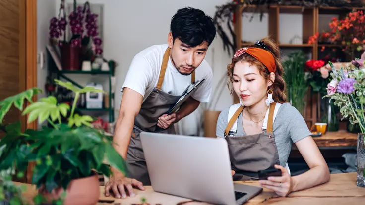 Shop owners looking at their laptop.