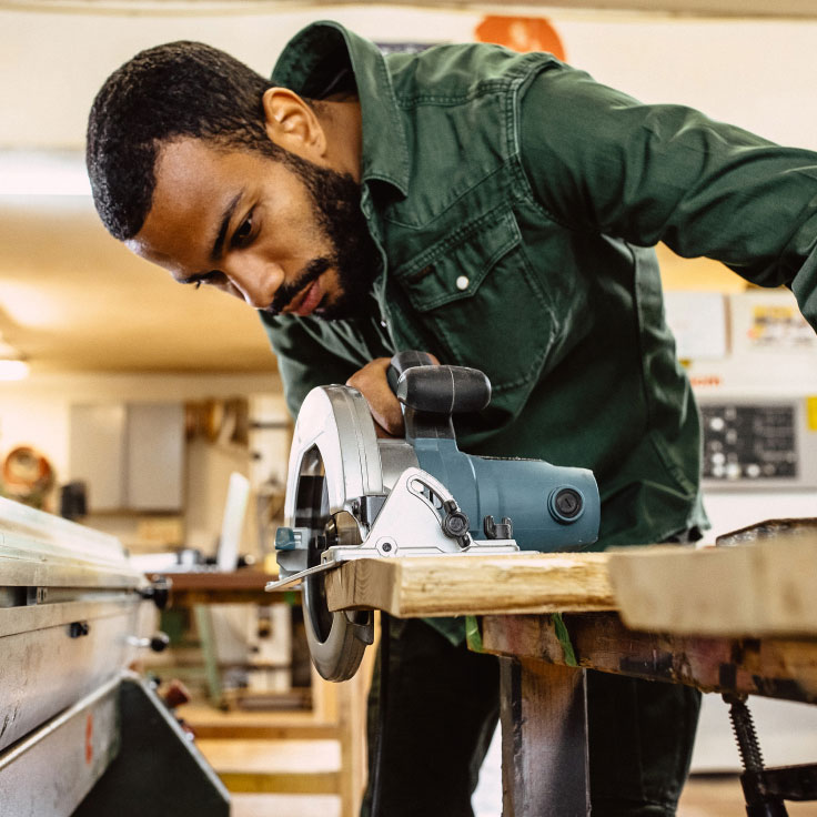 Man using wood-working equipment.