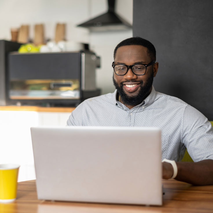 Man working at a laptop in a cafe.