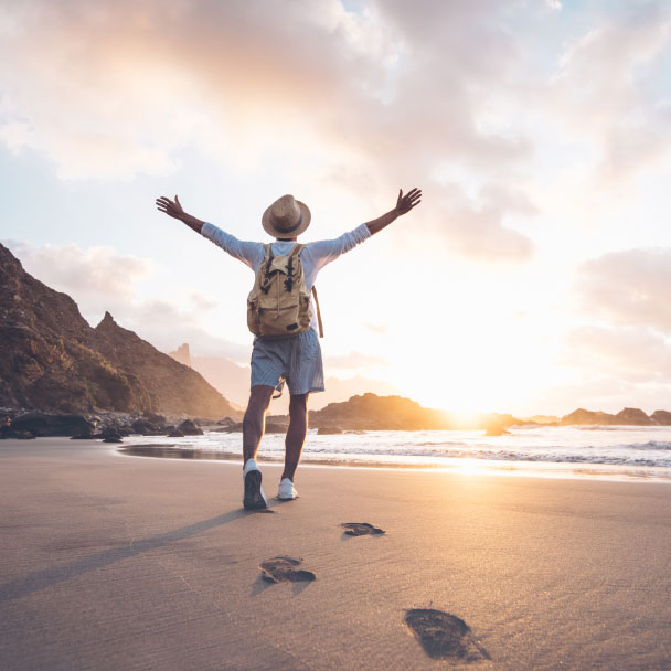 Traveler enjoying the sunset on an empty beach.