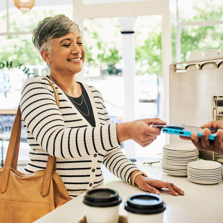 Woman using her contactless credit card to make a purchase.