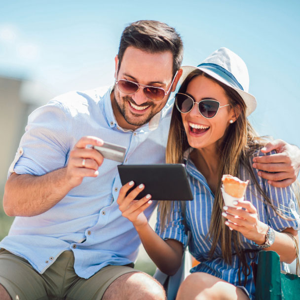 Young, happy couple use their credit card while eating ice cream.