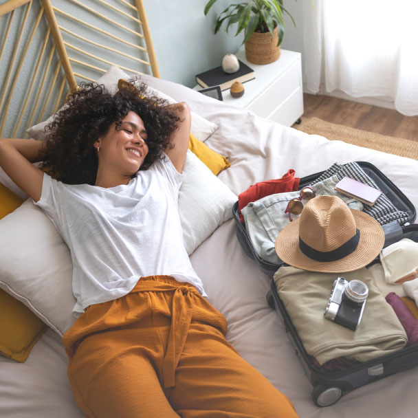 A young woman takes a break from packing for her vacation.