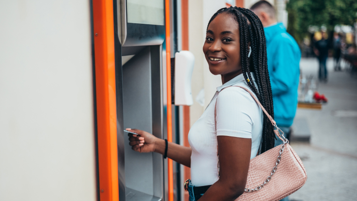 Young woman using  ATM.