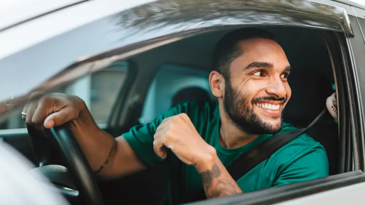 Man talking to someone through his car window.