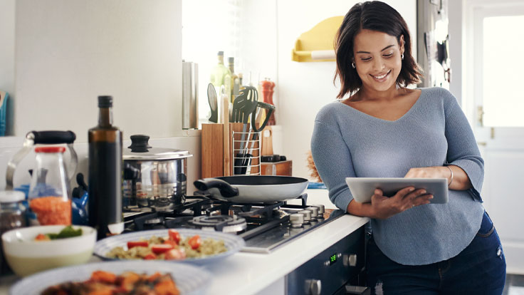 Woman planning a menu in her kitchen.